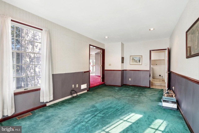 unfurnished room featuring dark colored carpet