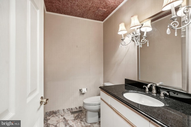 bathroom with crown molding, vanity, and toilet