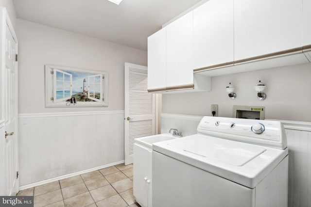 laundry room with light tile patterned floors, washer / clothes dryer, and cabinets