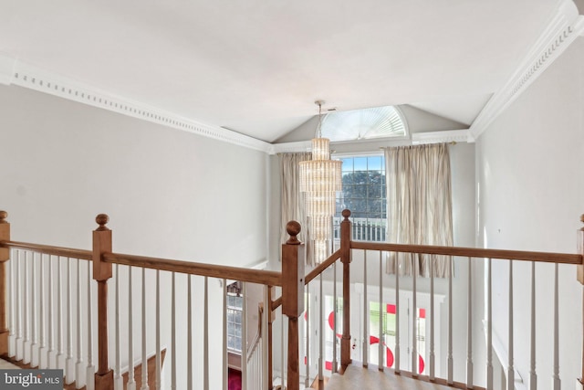 corridor with a notable chandelier, crown molding, and vaulted ceiling