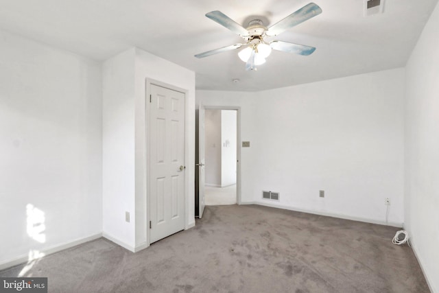 carpeted spare room with ceiling fan