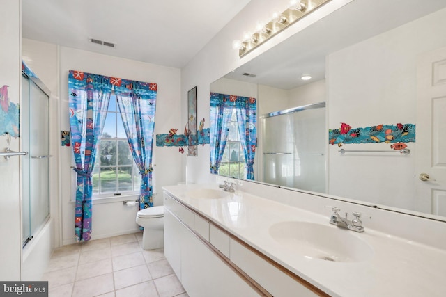 full bathroom featuring vanity, tile patterned flooring, toilet, and combined bath / shower with glass door