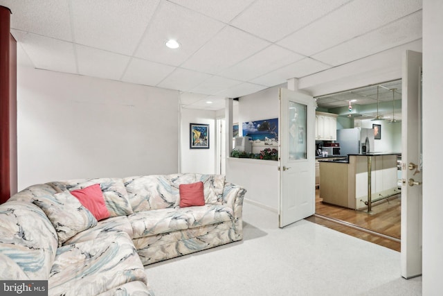 carpeted living room with a drop ceiling