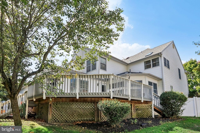 rear view of property featuring a wooden deck