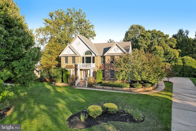 view of front of property featuring a front yard and a balcony