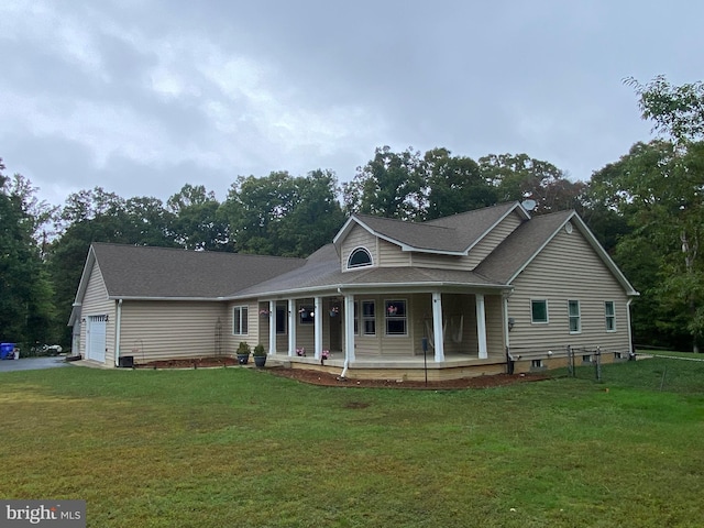 view of front of property featuring a garage, a front lawn, and covered porch