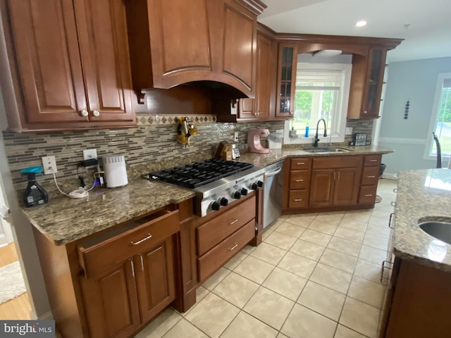 kitchen featuring light tile patterned flooring, sink, tasteful backsplash, stone countertops, and appliances with stainless steel finishes