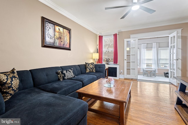 living room featuring crown molding, hardwood / wood-style floors, ceiling fan, and french doors