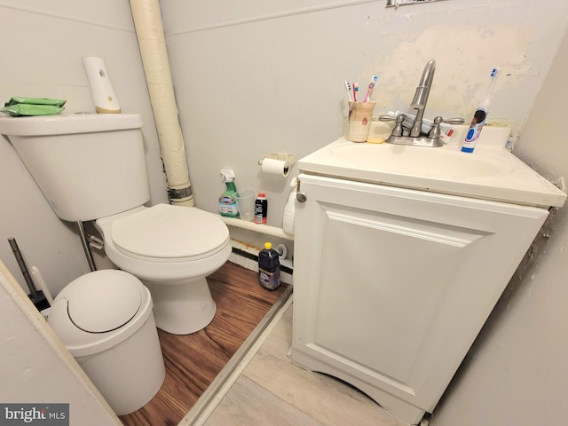 bathroom with vanity, toilet, and hardwood / wood-style floors