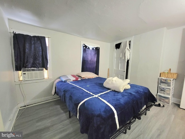 bedroom with cooling unit and hardwood / wood-style floors