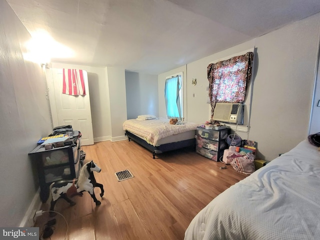 bedroom with hardwood / wood-style flooring and cooling unit