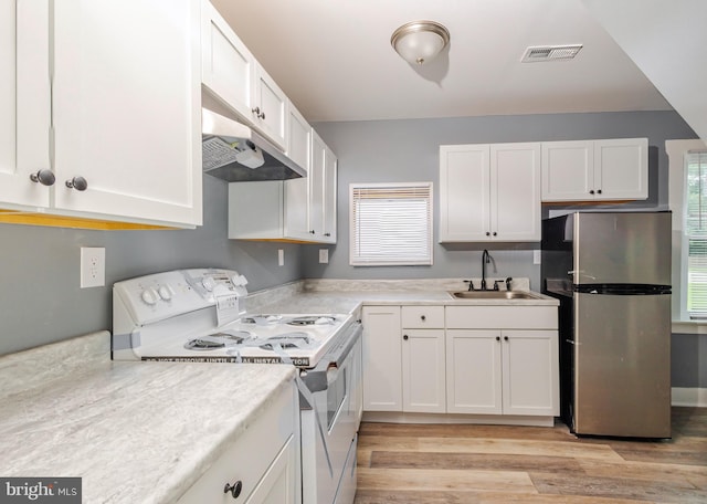 kitchen with white cabinetry, stainless steel refrigerator, light wood-type flooring, white electric range, and sink