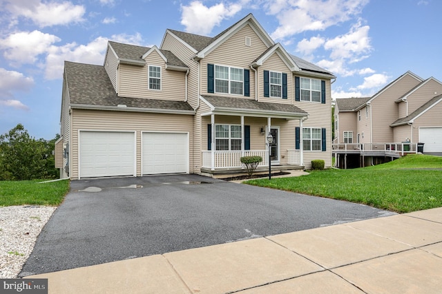 view of front of home with a porch, a garage, and a front yard