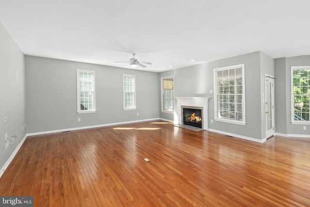 unfurnished living room with ceiling fan and wood-type flooring