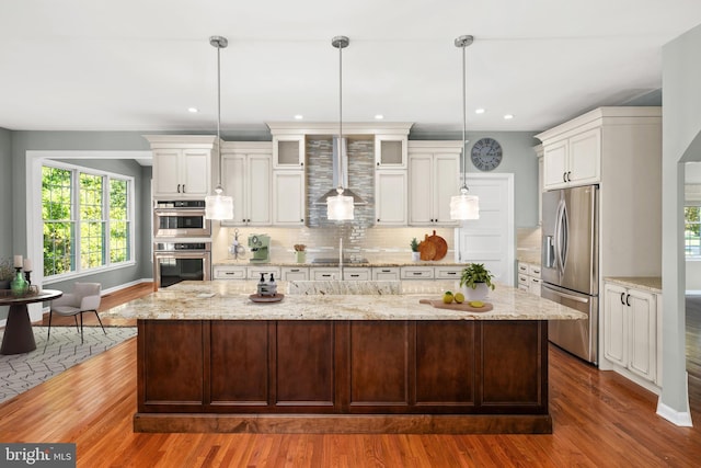 kitchen with a center island, stainless steel appliances, dark hardwood / wood-style flooring, pendant lighting, and decorative backsplash