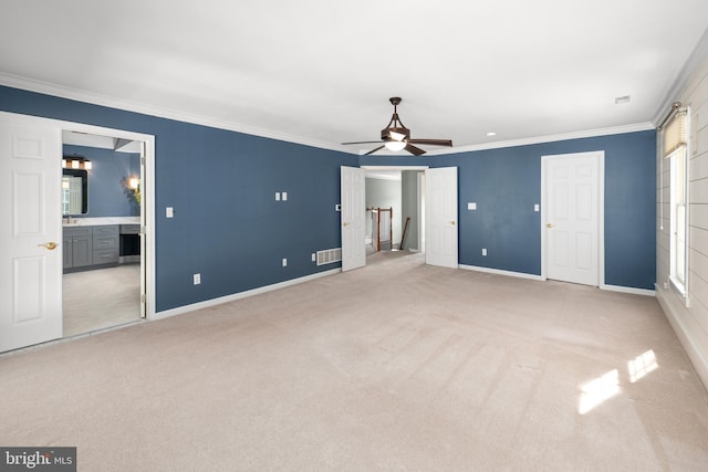 unfurnished bedroom featuring light colored carpet, ensuite bath, multiple windows, and crown molding