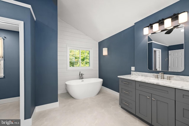 bathroom featuring a bathing tub, vanity, ceiling fan, tile patterned flooring, and lofted ceiling