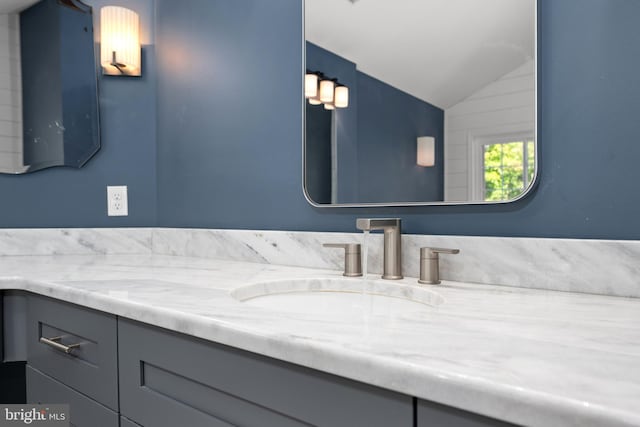 bathroom featuring vanity and lofted ceiling