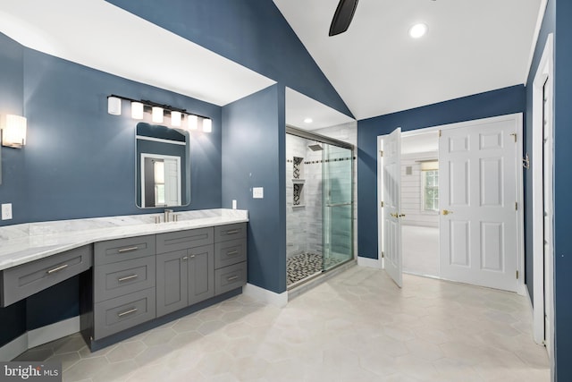 bathroom with ceiling fan, vanity, lofted ceiling, and walk in shower