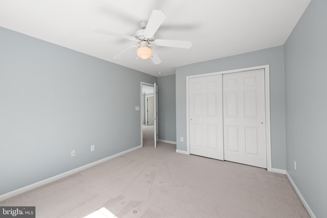 unfurnished bedroom featuring ceiling fan, a closet, and light carpet