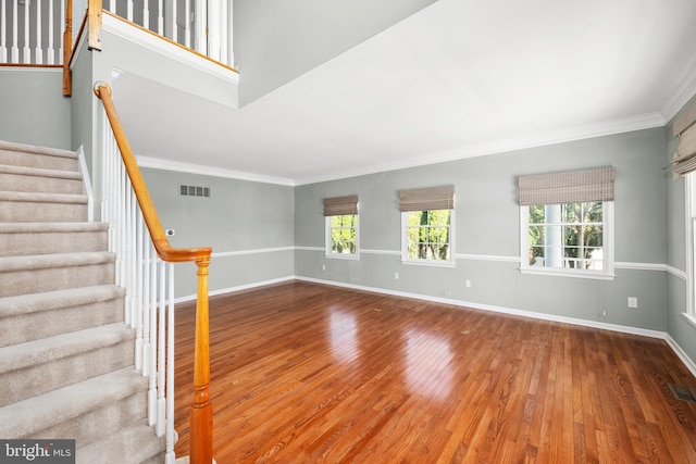 interior space with wood-type flooring and crown molding