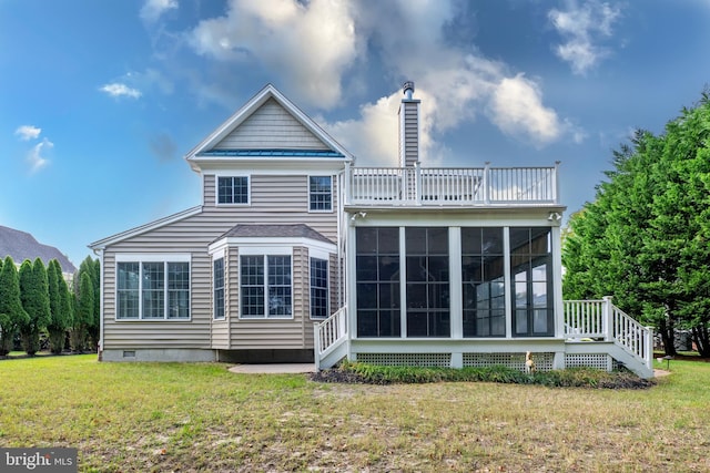 rear view of house featuring a sunroom and a yard