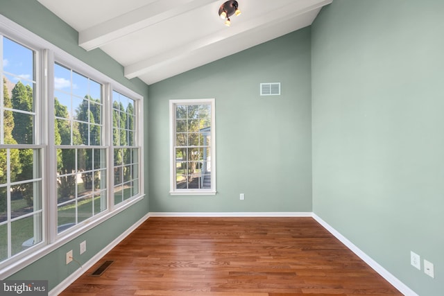 empty room featuring hardwood / wood-style floors and lofted ceiling with beams