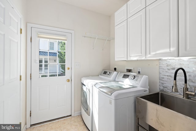 laundry room featuring washer and clothes dryer, cabinets, and sink