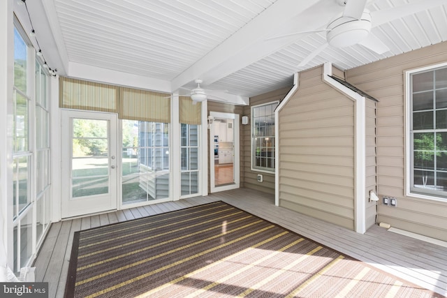 unfurnished sunroom featuring ceiling fan and beam ceiling