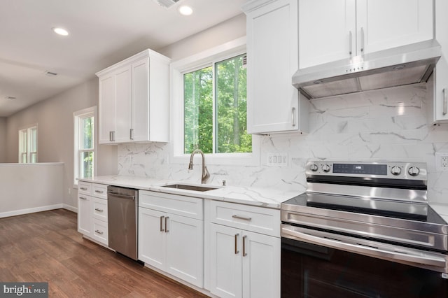 kitchen featuring appliances with stainless steel finishes, light stone counters, sink, dark hardwood / wood-style floors, and white cabinetry