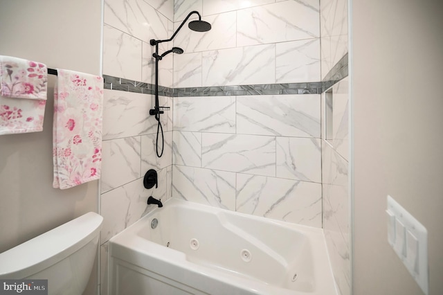 bathroom with tiled shower / bath combo and toilet