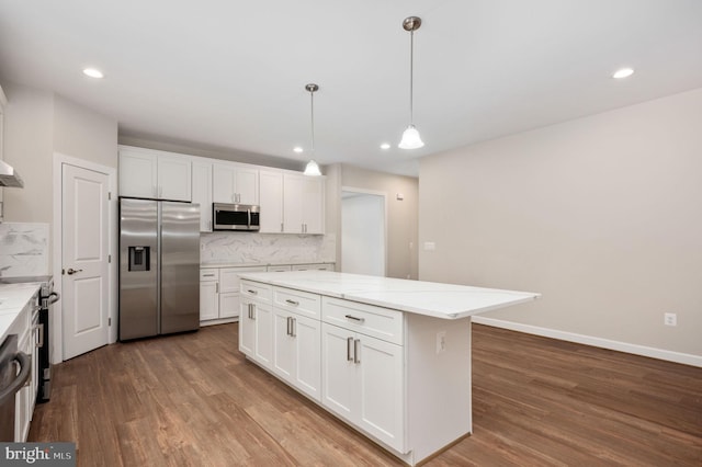 kitchen featuring decorative backsplash, appliances with stainless steel finishes, decorative light fixtures, and white cabinetry