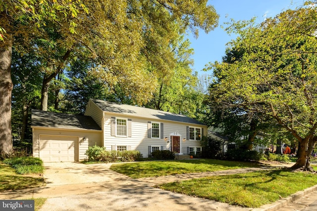 split foyer home with a garage and a front yard