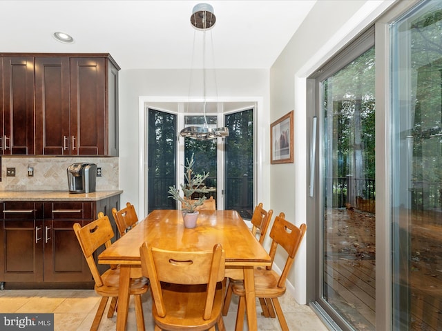 dining room with light tile patterned floors and a chandelier