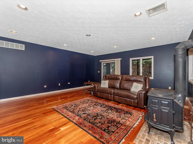 living room with a wood stove and hardwood / wood-style flooring