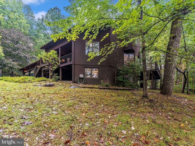 view of side of property with a deck and a yard