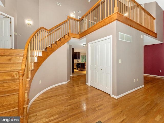 staircase featuring a high ceiling and hardwood / wood-style floors