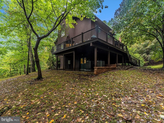 rear view of property with a wooden deck and central air condition unit