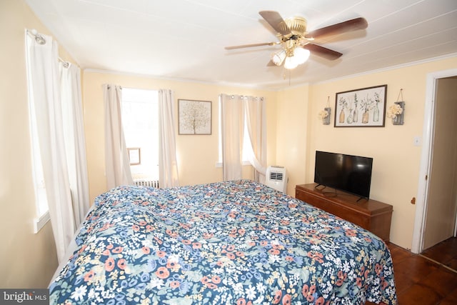 bedroom featuring multiple windows, crown molding, hardwood / wood-style floors, and ceiling fan