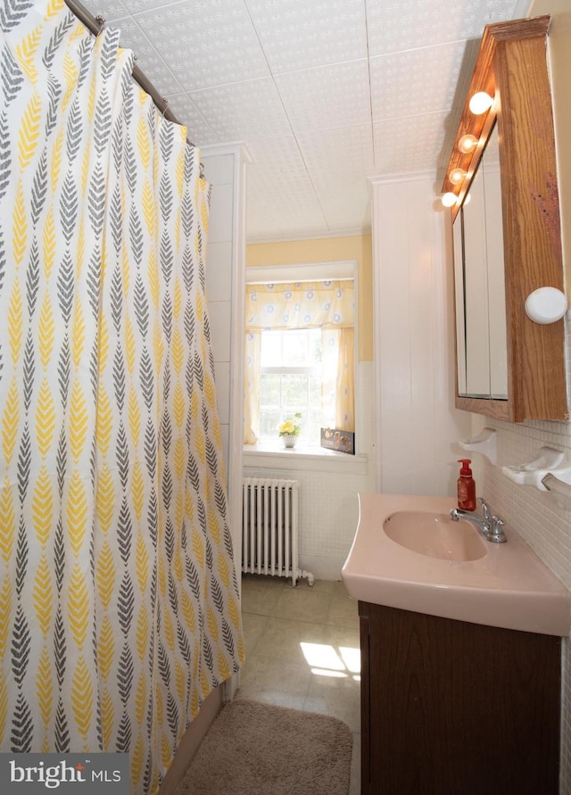 bathroom featuring radiator, walk in shower, and vanity