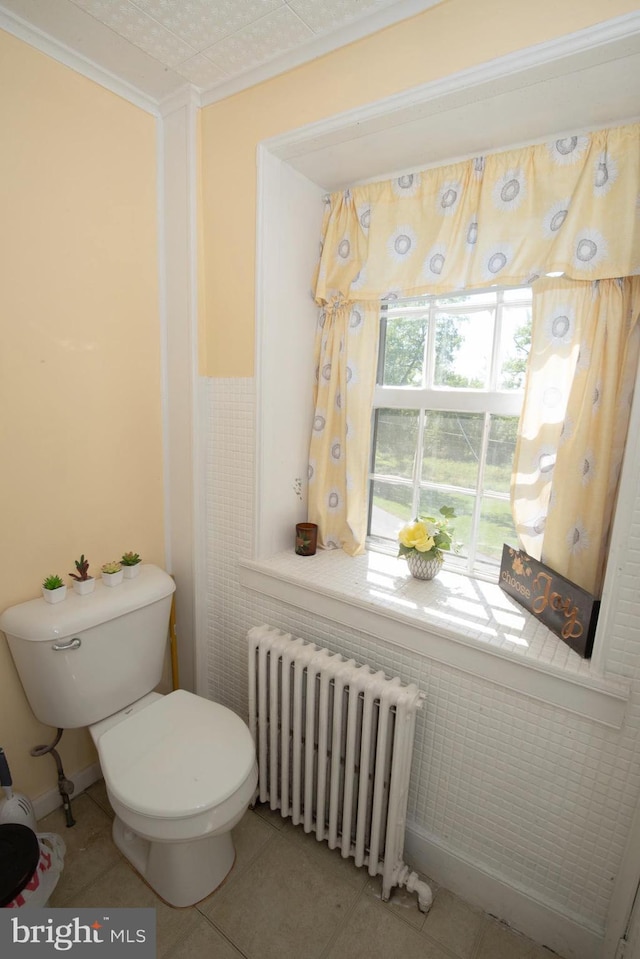 bathroom featuring radiator, tile patterned flooring, and toilet