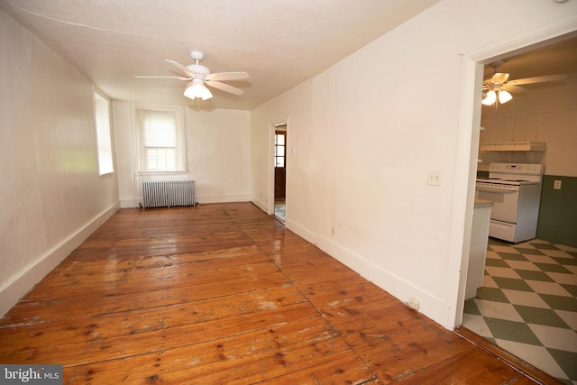 unfurnished room with radiator, ceiling fan, and hardwood / wood-style floors