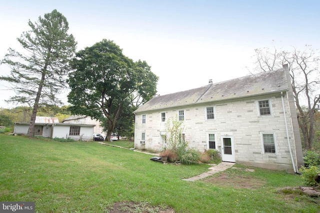 back of property featuring a lawn