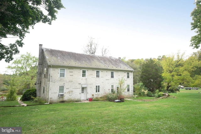 back of house featuring cooling unit and a yard