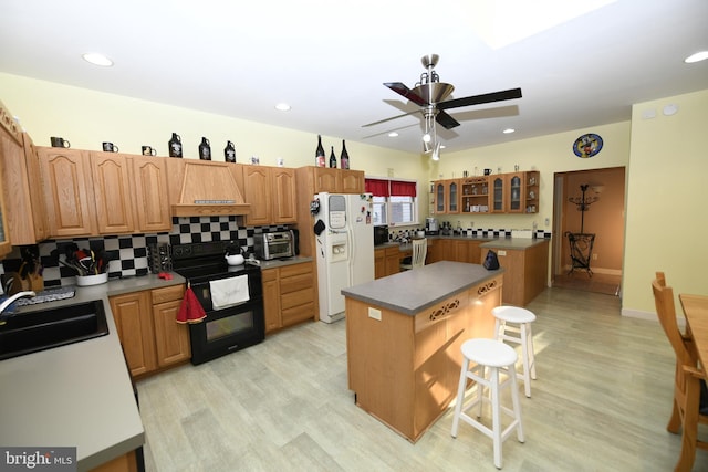 kitchen with custom exhaust hood, electric range, a kitchen island, white fridge with ice dispenser, and a breakfast bar