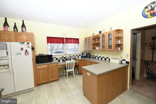 kitchen with white fridge with ice dispenser, built in desk, backsplash, kitchen peninsula, and light hardwood / wood-style flooring