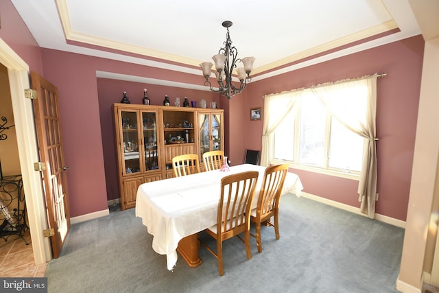 dining space with an inviting chandelier, light colored carpet, a tray ceiling, and baseboards