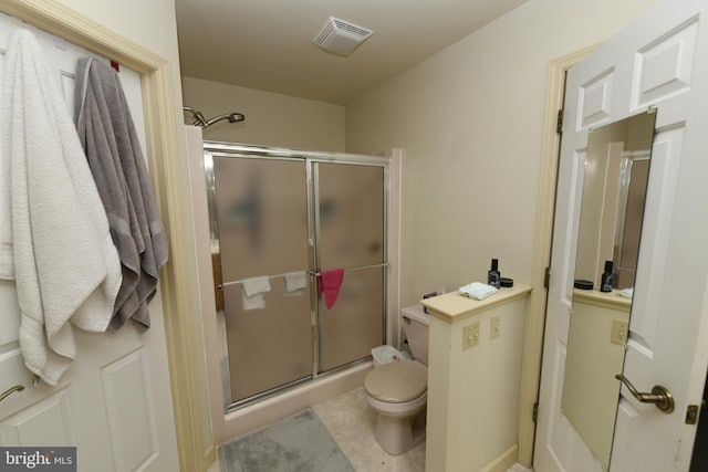 bathroom featuring toilet and an enclosed shower