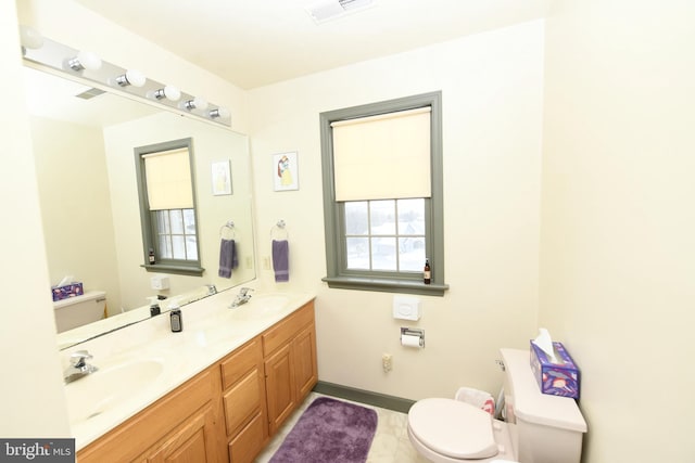 bathroom featuring visible vents, toilet, and a sink