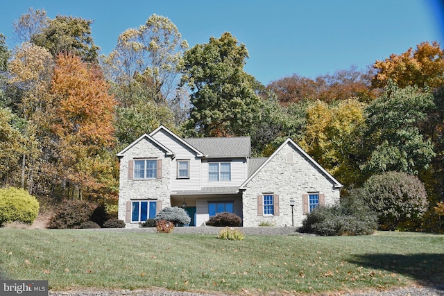 traditional-style house with a front yard and stone siding